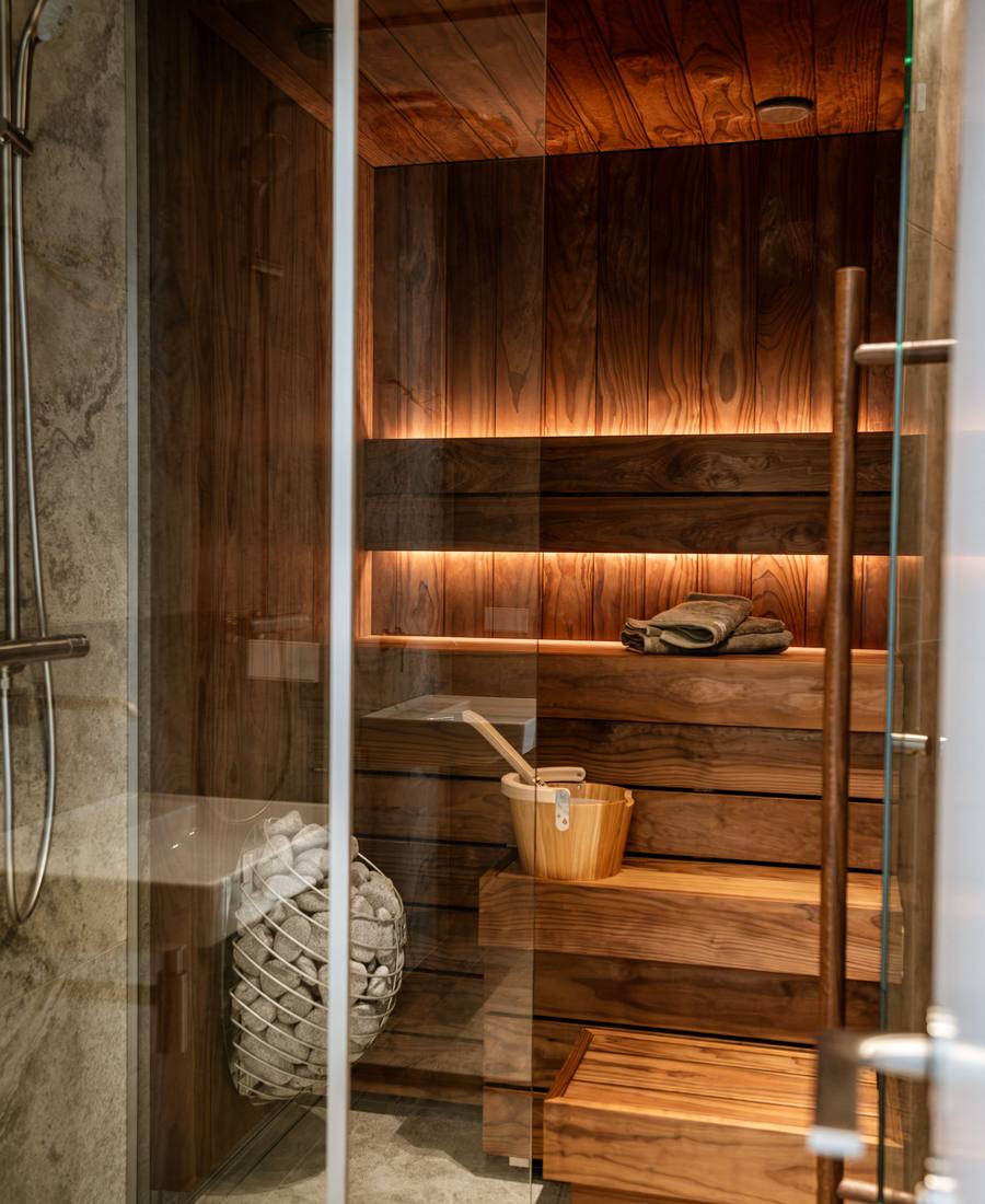 A glass-fronted indoor sauna beside a walk-in shower